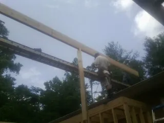 Carpenter setting a ridge beam over a new addition frame — Ice Dam Removal by Roofing Brothers in Walnut Grove